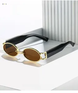 Detail of vintage oval sunglasses with gold metal frame and thick black temples on a pedestal
