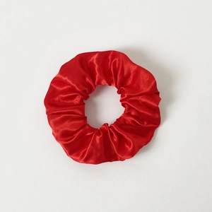 Close-up of a red satin LED hair scrunchie with a glossy finish on white background
