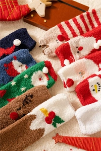 Detail of assorted Christmas coral fleece socks with festive patterns on plush background
