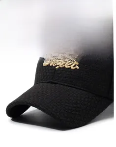 Détail d'une casquette noire à texture quadrillée avec broderie dorée Sweet