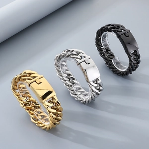 Dettaglio di bracciali a catena cubana in oro, argento e nero con chiusure a incastro