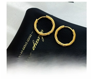 Detail shot of golden twisted hoop earrings in vacuum-plated titanium steel with a sleek finish