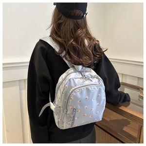 Close-up of mini floral backpack featuring pink flower patterns on light gray nylon