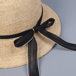 Handwoven raffia sun hat with a dome top and a black bow detail for summer travel