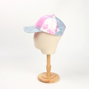 Detail of tie-dye baseball cap featuring pink and blue ink wash patterns and frayed brims