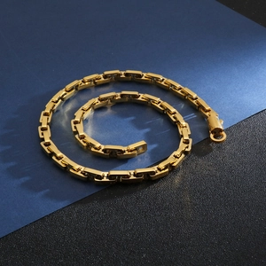 Detailed close-up of golden stainless steel geometric chain links with a spring clasp