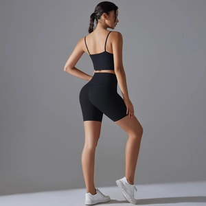 Vista laterale posteriore di un set yoga nero con top corto e pantaloncini da ciclista