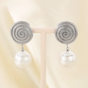 Detailed macro view of French spiral silver earrings with elegant white pearl drops