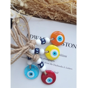 Detailed close-up of colorful glass evil eye charms with handmade natural hemp rope