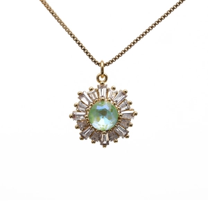 Golden sunburst necklace featuring a green center stone and rectangle zircon petals