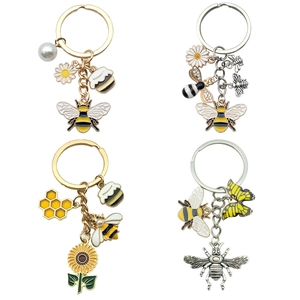 Detailed view of bee, sunflower, and honeycomb enamel keychains with golden alloy finish