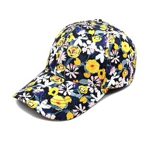 Détail de casquette de baseball bleu foncé avec imprimé floral jaune et texture en sergé