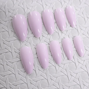 Glossy lavender almond-shaped press-on nails set on a white woven textured background