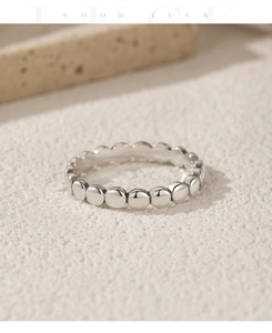 Macro shot of S925 sterling silver beaded ring on a minimalist stone background