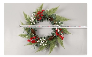 Close-up of Christmas wreath showing green eucalyptus leaves, red berries, and pine cones