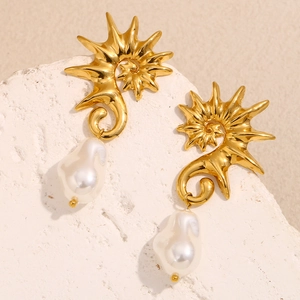 Gros plan détaillé des boucles d'oreilles hippocampe dorées avec perles baroques