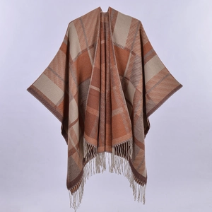 Detailed view of thick checkered knit shawl with fringe tassels in earth tone colors
