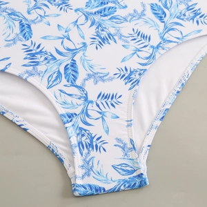 Detail of tropical leaf print on one-piece swimsuit with reinforced stitching and white lining