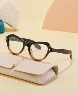 Dettaglio di occhiali da sole cat-eye con montatura sfumata e custodia in pelle beige