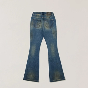 Detailed back view of flared denim jeans with vintage wash and distressed yellow tint