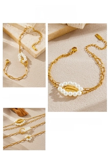 Detailed view of gold plated chain bracelet with white pearls and shell charms