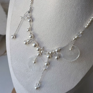 Detail of shell pearl fringe necklace with silver chain and elegant tassels on mannequin