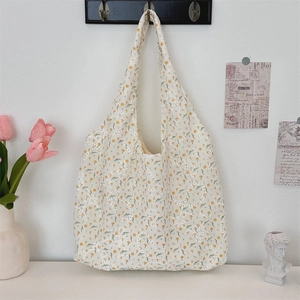 Detailed close-up of a floral canvas tote bag with embroidered yellow and orange flowers
