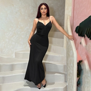 Schwarzes Kleid mit tiefem V-Ausschnitt auf weißer Wendeltreppe in körpernaher Passform