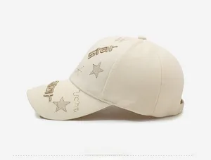 Detailed side view of beige baseball cap featuring gold star embroidery and canvas texture