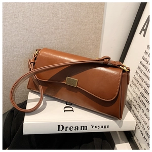 Detailansicht einer braunen Hochglanz-Ledertasche mit goldenem Metallverschluss