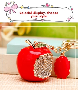 Detailed view of red apple keychain with sparkling rhinestones and golden hardware