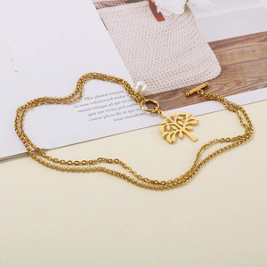 Golden double layer Tree of Life necklace with pearl pendant and OT clasp on beige background