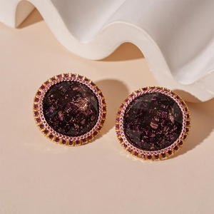 Vue détaillée de boucles d'oreilles rondes vintage avec résine et détails dorés