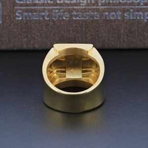 Macro shot of the smooth inner band and brushed gold finish of the men's star ring
