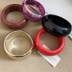 Chic set of 5 thick resin bangles in amber, marble, and gold for retro fashion style