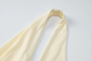 Detail shot of light yellow knitted fabric with ribbed texture and backless straps