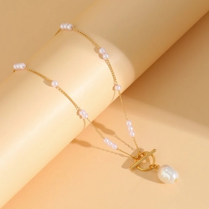 Detail of gold chain necklace featuring baroque pearl pendant and OT toggle clasp closure