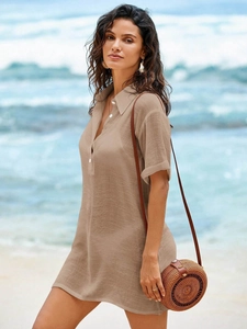Detail of tan linen beach cover-up featuring button neckline and breathable texture