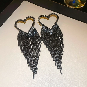 Détail des boucles d'oreilles pampilles en strass noir en forme de cœur fini métal