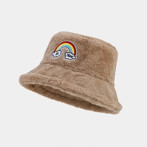 Détail d'un bob en peluche marron avec broderie arc-en-ciel et texte 'OH YEAH'
