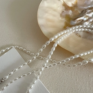 Close-up of elegant small oval pearl necklace with natural iridescent luster details