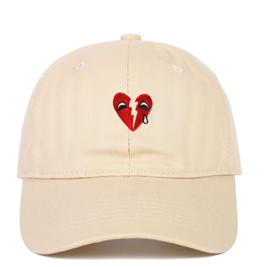 Beige cotton baseball cap with broken heart embroidery and cartoon eyes on white background
