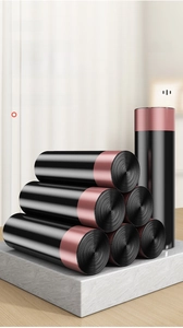 Close-up of durable black drawstring garbage bags on a marble surface in rolls