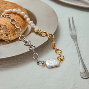 Baroque pearl necklace with mixed gold and silver stainless steel chain in flat lay