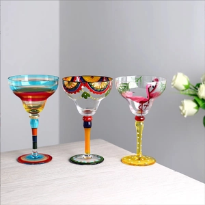 Three creative hand-painted margarita glasses with striped, floral, and flamingo patterns