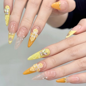 3D floral press-on nails in vibrant orange with crystals and pearls on almond shape