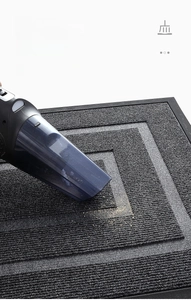 Vacuuming a grey striped commercial entrance mat with a black rubber border