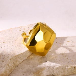 Detail of a vintage gold-tone stainless steel ring with a geometric faceted floral design