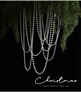 Close-up of clear crystal beaded garland hanging from a Christmas tree branch