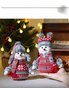Close-up of a pair of knit Christmas snowman dolls in red and grey with snowflakes